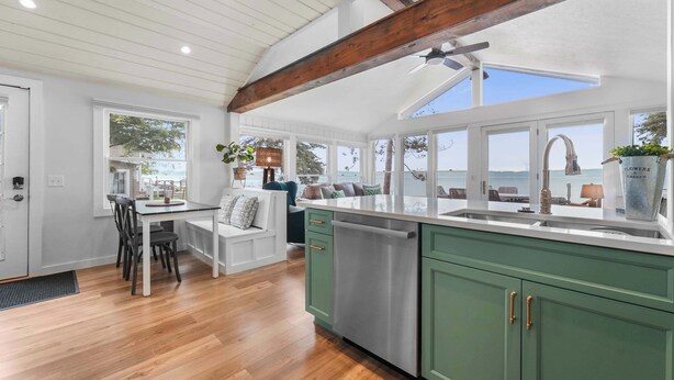 Une cuisine avec un plafond en bois, une grande fenêtre et une vue sur la mer.