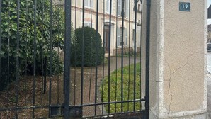 Ein verschlossenes Tor mit einer Steinmauer und einer Nummertafel.