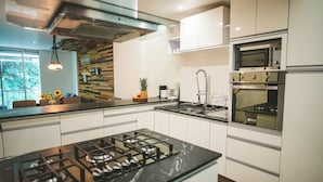 Une cuisine moderne équipée d’une cuisinière à gaz, d’un four à micro-ondes et d’un four encastré.