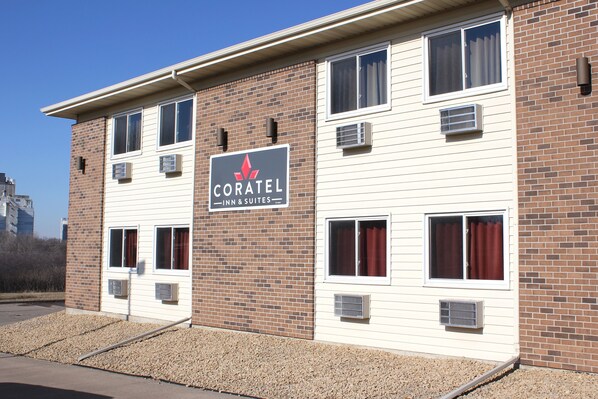 Il s'agit d'un hôtel dont l'enseigne indique « CORATEL INN & SUITES ». Il se distingue par sa façade en briques, dotée de nombreuses fenêtres et de plusieurs unités de climatisation.
