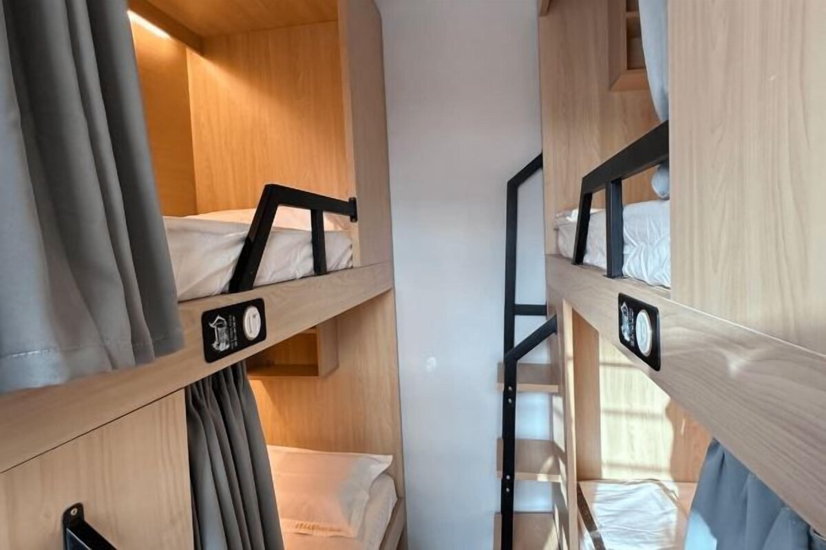 A bunk bed room with wooden walls and a small staircase.