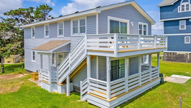A two-story house with a balcony, a staircase, and a small deck area.