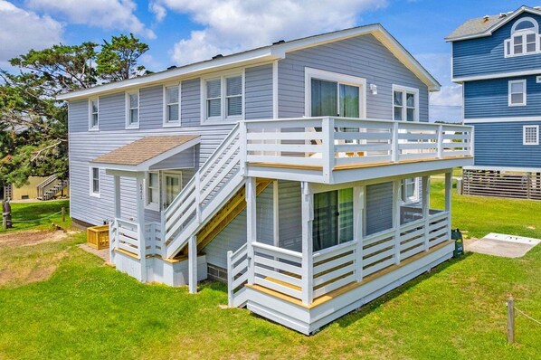 A two-story house with a balcony, a staircase, and a small deck area.