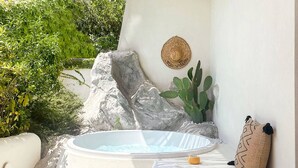 Een wellnessruimte met een jacuzzi, een handdoek en een decoratieve wand.