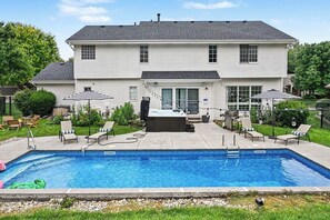 A two-story house with a swimming pool, outdoor seating, and a hot tub. - Prestige Retreat! Pool & Hot tub w/ Private Yard! (Omaha)