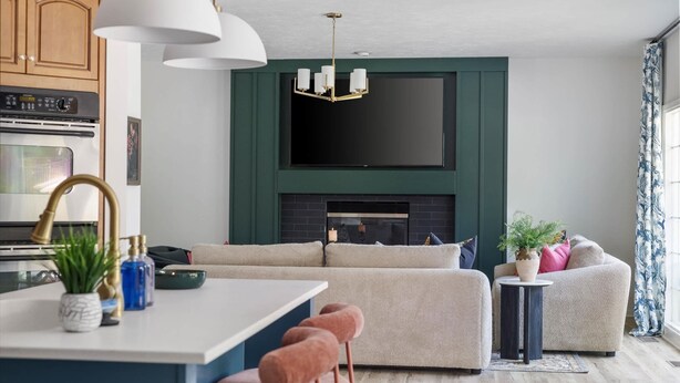 A modern kitchen with a central island, a built-in oven, and a large window.
