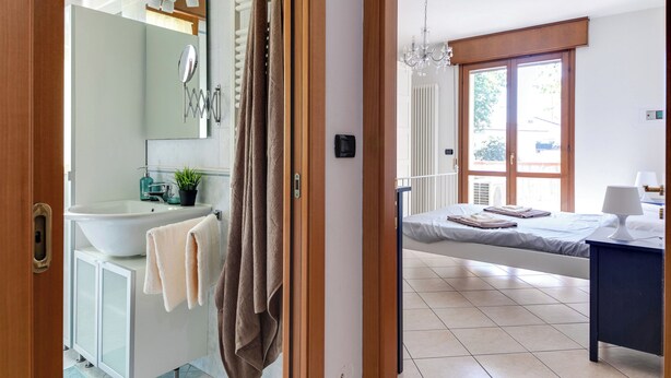 A modern bathroom with a large sink, mirror, and towel rack. - 2 Bedroom Apartment in Cesena (Cesena)
