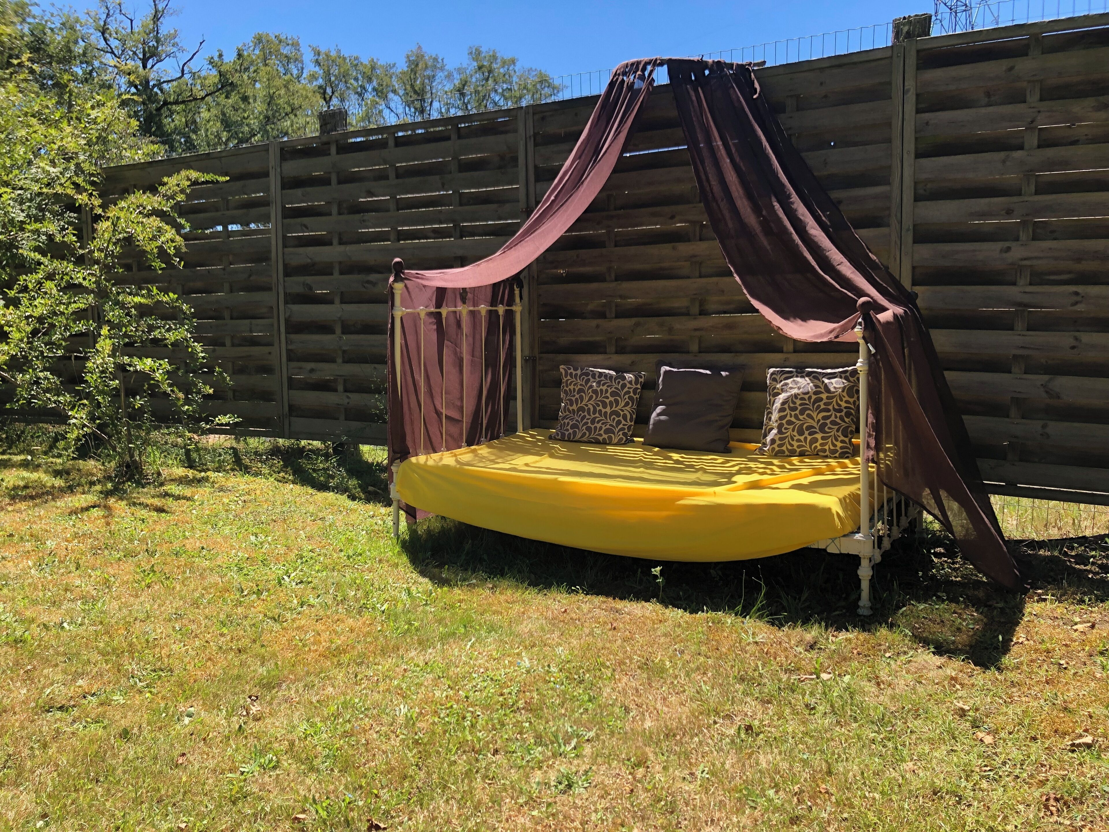 Un lit à baldaquin situé dans un espace extérieur clos.