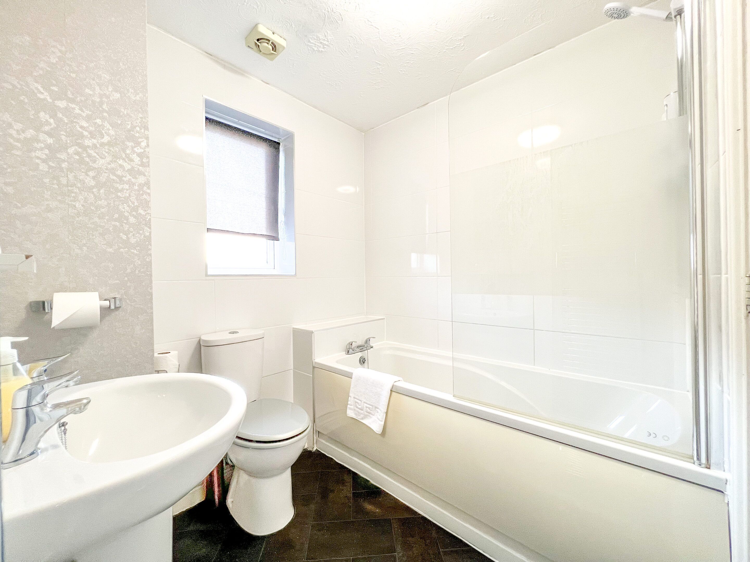 Een badkamer met toilet, wastafel en bad.