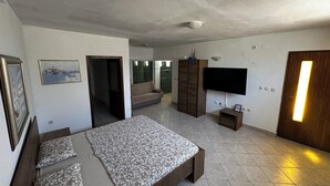 A bedroom with a bed, a sofa, a TV, and a wardrobe. - Villa Klisovic (Rogoznica)