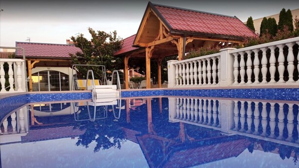 A swimming pool with a wooden deck and a white balustrade. - Villa Klisovic (Rogoznica)