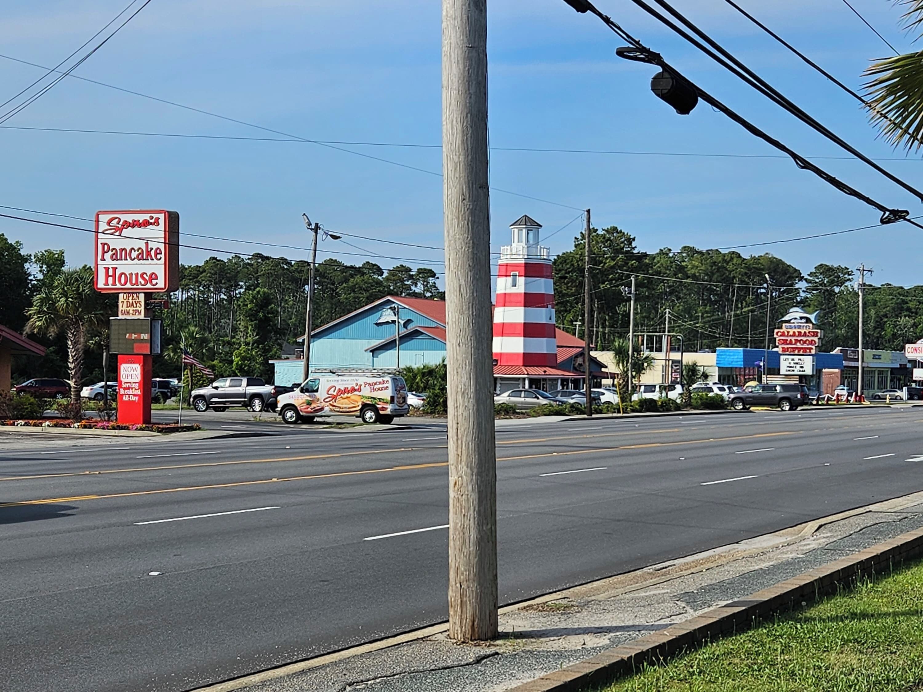 A street view with a red and white striped lighthouse, a 'Samo's Pancake House' sign, and a 'Calabash Seafood Buffet' sign.