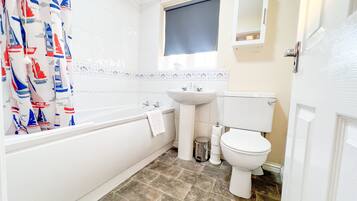 Un bagno con una vasca, un lavandino e un water.
