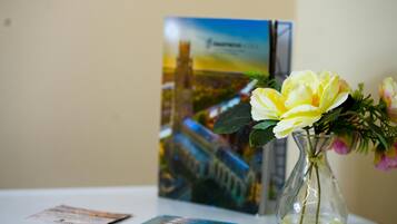 Une table avec un vase de fleurs et une brochure.