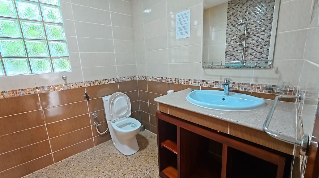 Une salle de bain comprenant des toilettes, un lavabo et une douche à parois en verre.