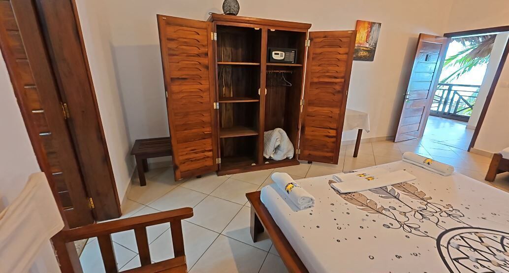 Ein Schlafzimmer mit Bett, Holzschrank und kleinem Tisch.