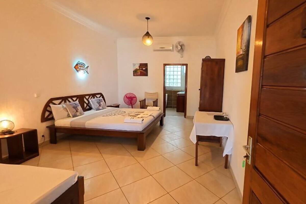 A bedroom with a bed, bedside table, and a wooden wardrobe.