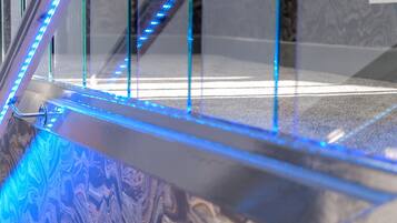 A close-up of a glass railing with blue LED lights.