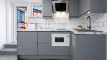 Mini-fridge, oven, stovetop, cookware/dishes/utensils