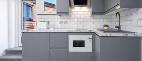Mini-fridge, oven, stovetop, cookware/dishes/utensils