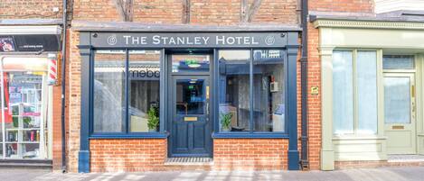 The Stanley Hotel with a traditional brick facade, large windows, and a prominent entrance.