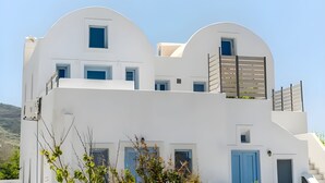 A modern white building with multiple windows and a balcony. - ACL'L Luxury Suites (Santorini)