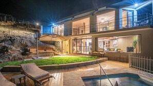 Area esterna su più livelli con piscina, poltrona relax e zona pranzo.