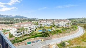 A residential area with multi-story buildings, a curved road, and a distant mountain range. - Fantastic 4 bed apt La Cala Hills (Mijas Costa)