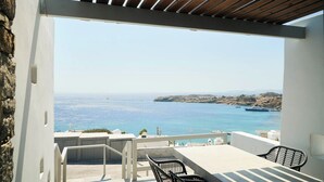 Une terrasse avec vue sur la mer, une table et deux chaises.