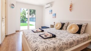 Un dormitorio con una cama grande, una mesita de noche, un reloj y vistas al exterior.