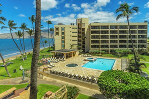 Un hôtel doté d’une piscine, de chaises longues et offrant une vue sur l’océan.