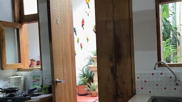 A kitchen with a wooden door leading to a patio area. - parrot house san antonio (Cali)