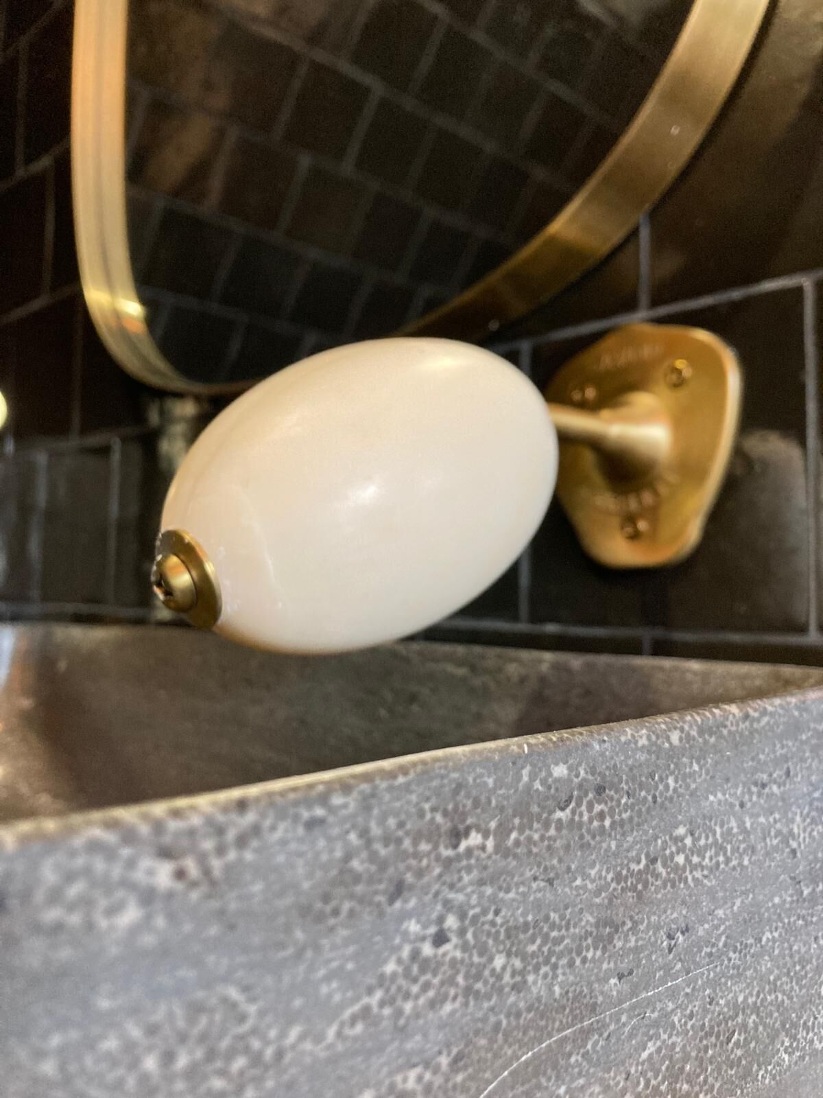 A kitchen sink with a white faucet and a brass faucet handle.