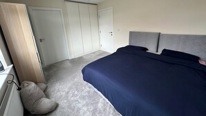 Un dormitorio con cama, radiador, armario y puerta.