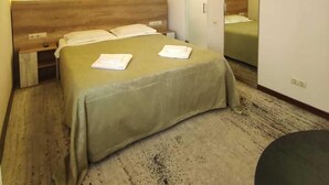 A hotel room with a bed, bedside tables, a mirror, and a carpeted floor. - EVN Boutique Hotel  (Yerevan)