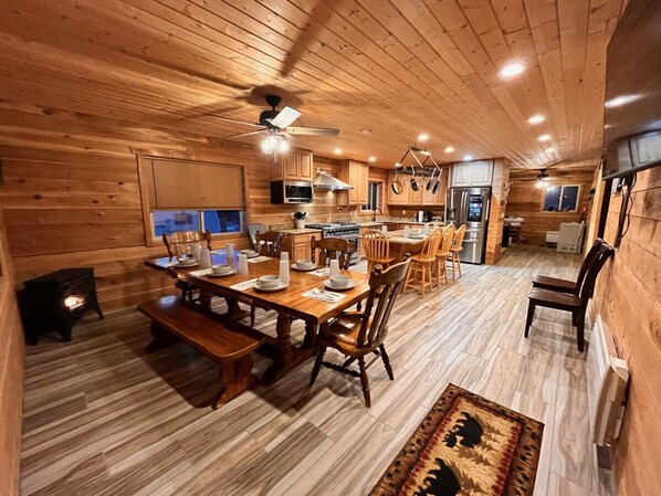 Ein gemütliches Holzhaus-Interieur mit Essbereich, Küche und Kamin.