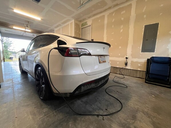 A white car parked in a garage with unfinished walls and a blue chair. - 12 miles from Yellowstone with incredible views - Grizzly Lodge (Island Park)