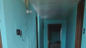 Un couloir avec un plancher en bois et des murs bleu clair.