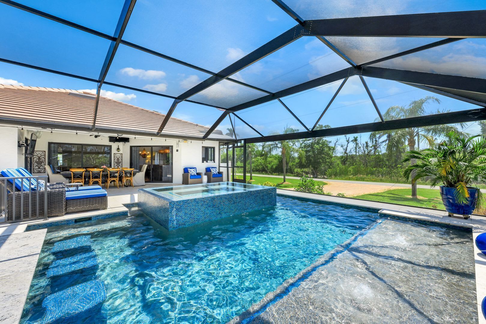 A covered swimming pool with a view of a house and landscape.