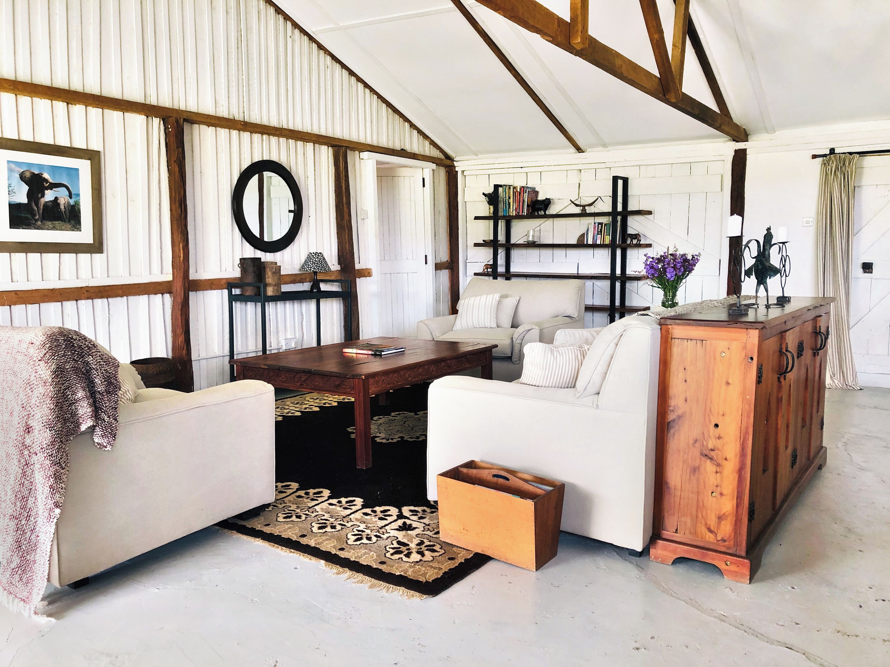 A cozy living room with a white sofa, a wooden coffee table, and a bookshelf.