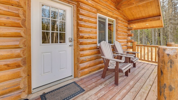 A log cabin with a porch, two Adirondack chairs, and a door. - Woodsy Cabin Near Kenai River: Great for Anglers! (Soldotna)