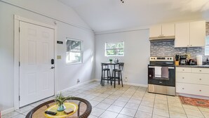 A spacious kitchen with white cabinets, a stainless steel oven, and a tiled backsplash. - Cozy St Pete Home ~ 2 Mi to Madeira Beach! (St. Petersburg)
