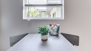 A dining table with a potted plant and a basket of items. - Cozy St Pete Home ~ 2 Mi to Madeira Beach! (St. Petersburg)