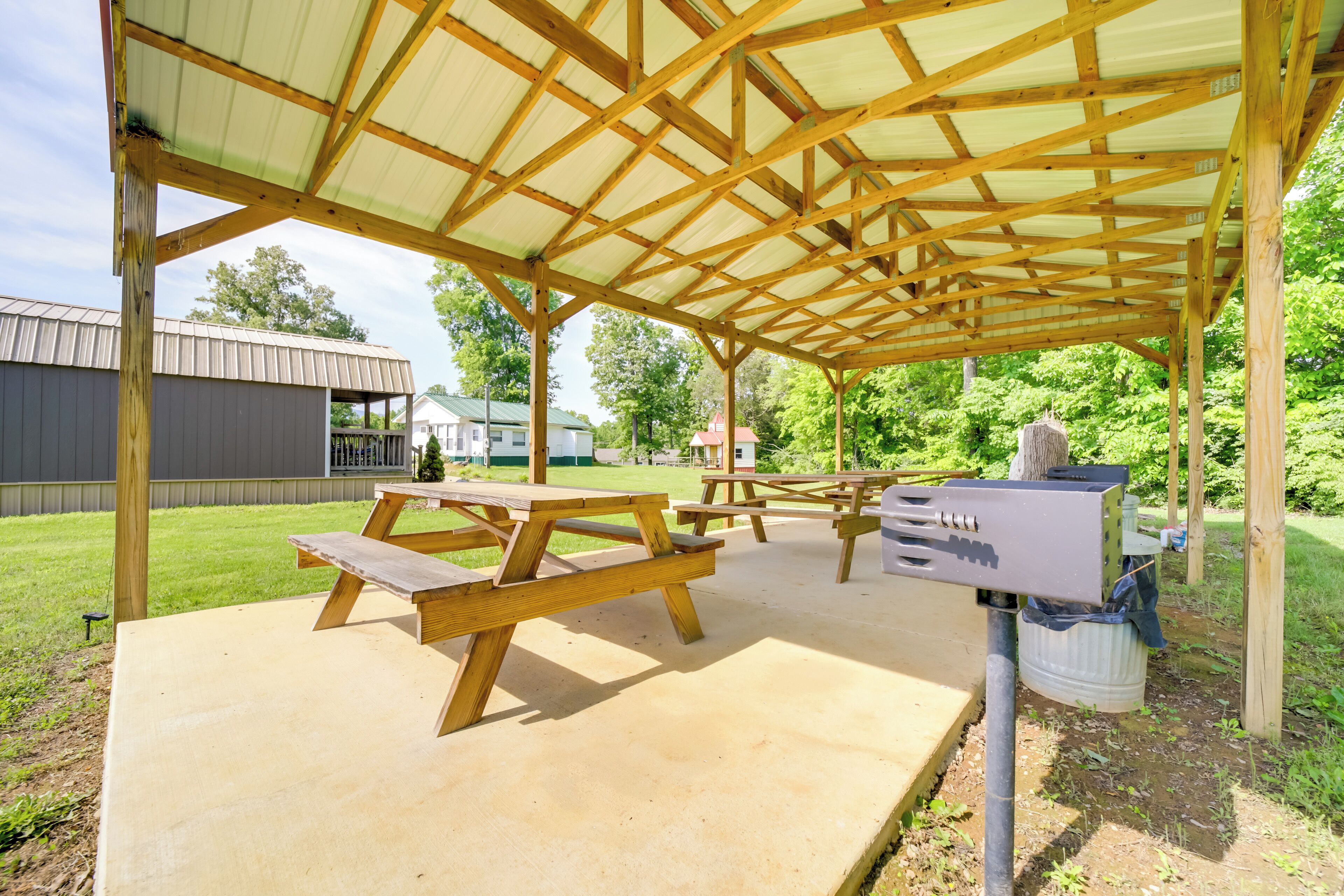 Un espace pique-nique abrité, doté de bancs en bois et d’une plateforme en béton.