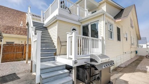 A two-story house with a covered porch, a grill, and a staircase leading to the upper level. - Wildwood Group Retreat: 2 Blocks to Boardwalk! (North Wildwood)