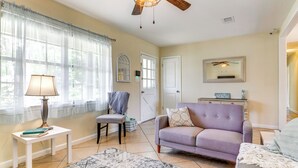 A living room with a ceiling fan, a sofa, a chair, a small table with a lamp, and a rug. - Pace Family Home: 1 Mi to Beach & Park! (Milton)