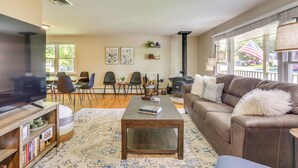 A living room with a sofa, coffee table, TV, bookshelf, and fireplace. - Charming Highland Falls Home < 2 Mi to West Point! (Highland Falls)