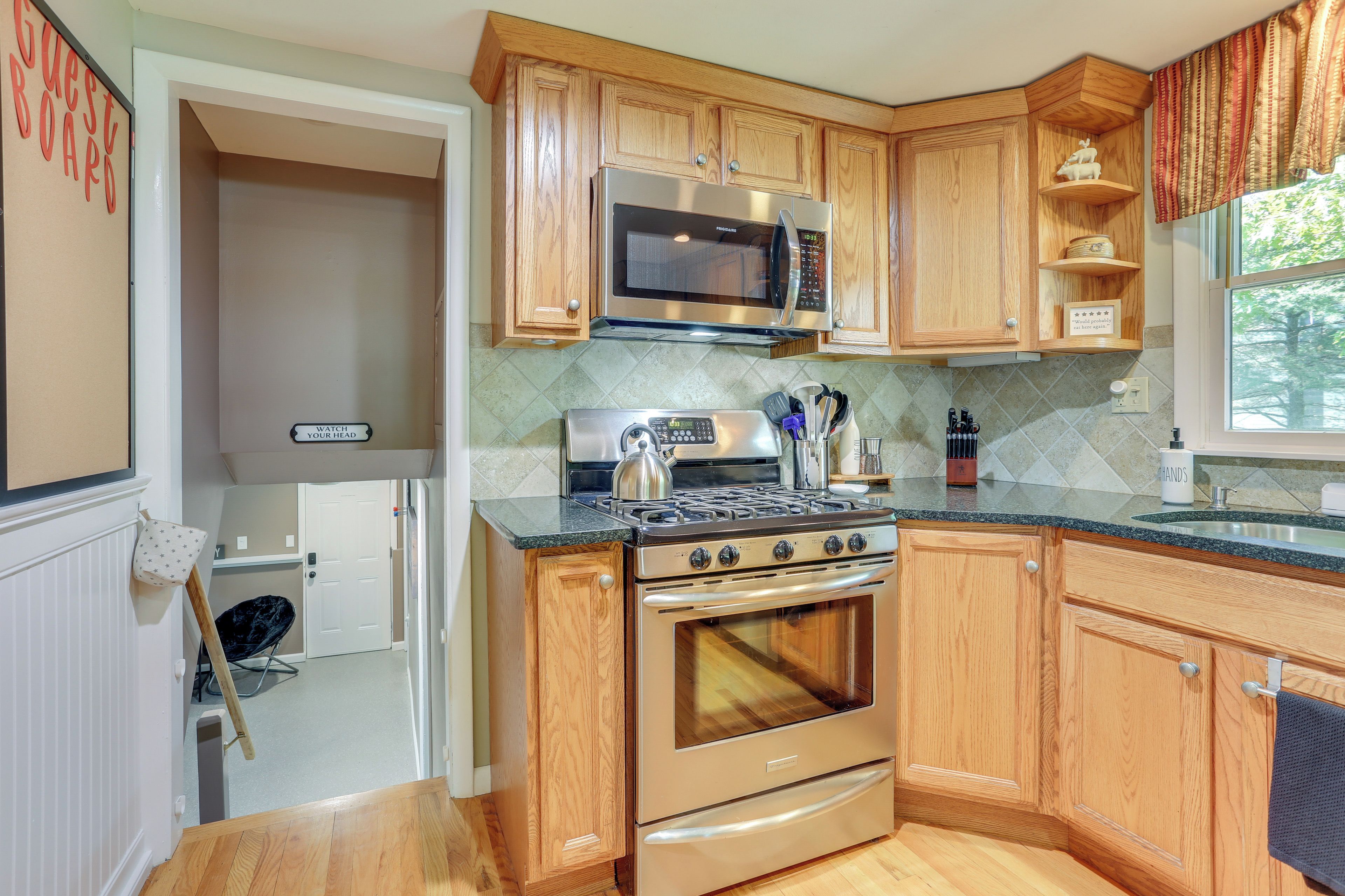 A kitchen with wooden cabinets, stainless steel appliances, and a granite countertop.