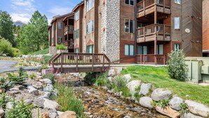 A multi-story wooden building with balconies and a stone pillar. - Streamside! Ski In/Out & Hiking (Breckenridge)