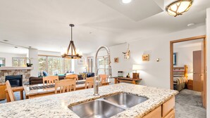 A modern kitchen with a granite countertop, stainless steel sink, and a unique curved faucet. - Streamside! Ski In/Out & Hiking (Breckenridge)